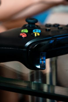 Detailed view of an Xbox controller on a reflective surface, showcasing gaming accessories.