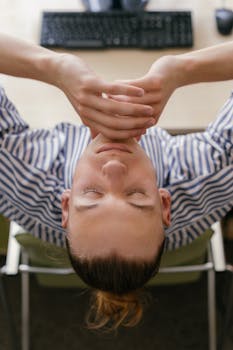 A young woman taking a break at a desk, seen from above in a relaxed pose.