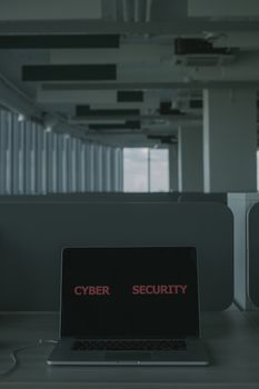 Laptop displaying 'Cyber Security' in a modern office setting, emphasizing tech and cybersecurity themes.