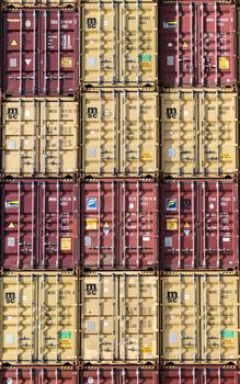 Vertical stack of red and yellow shipping containers, illustrating global logistics.